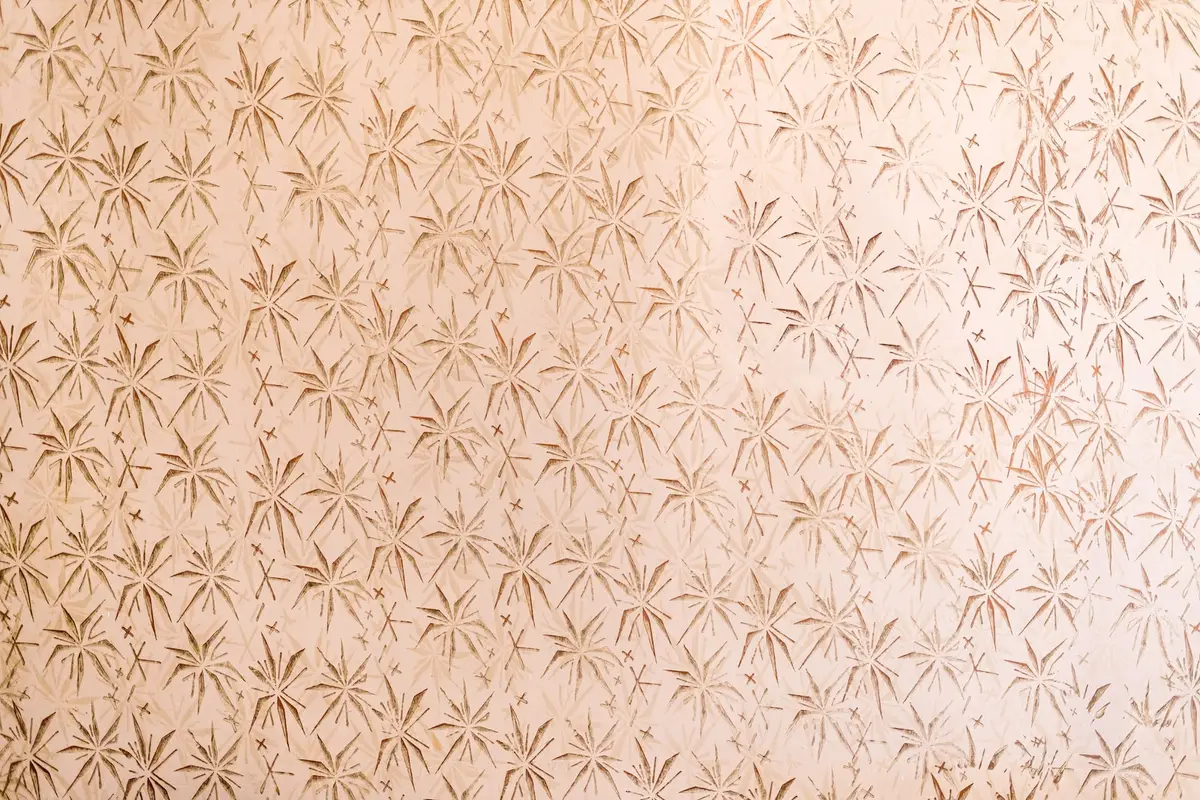 Personne retirant un lé de papier peint avec une large spatule