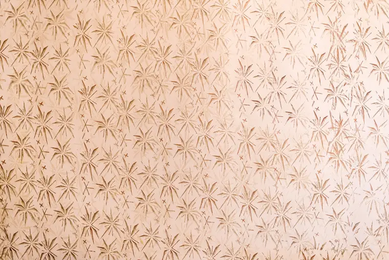 Personne retirant un lé de papier peint avec une large spatule
