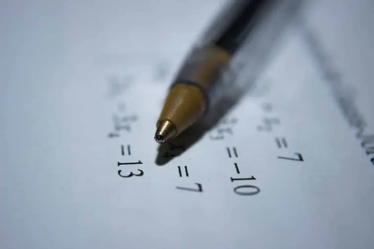 Élève calculant une multiplication de fractions sur papier quadrillé