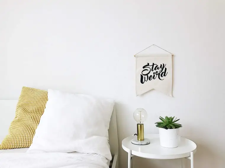 Personne rangeant des vêtements pliés dans un tiroir de chambre lumineuse