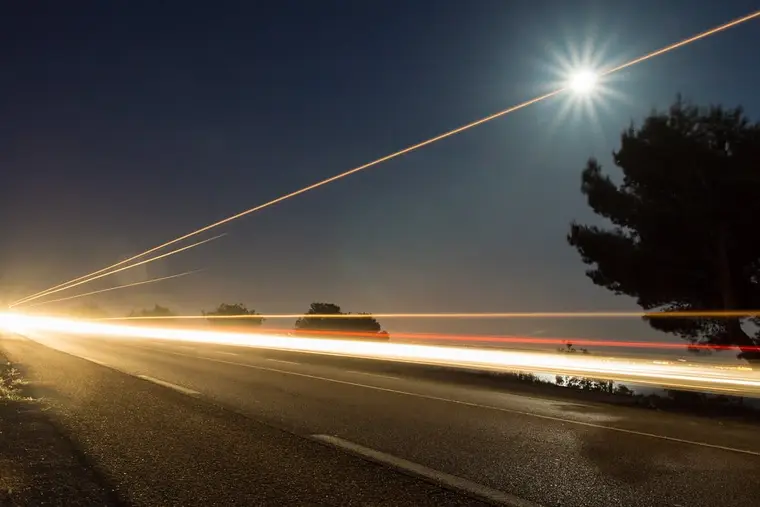 Lune gibbeuse lumineuse au-dessus d’arbres silhouettés dans un ciel nocturne clair