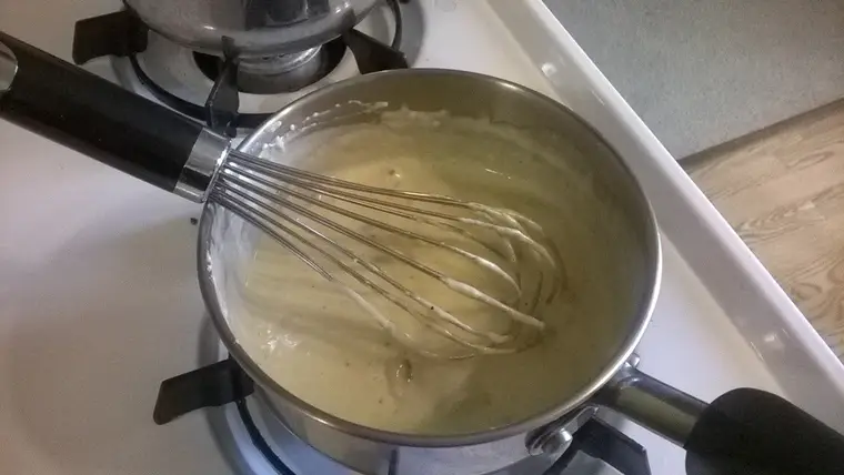 Béchamel lisse fouettée dans une casserole avec beurre, farine et lait