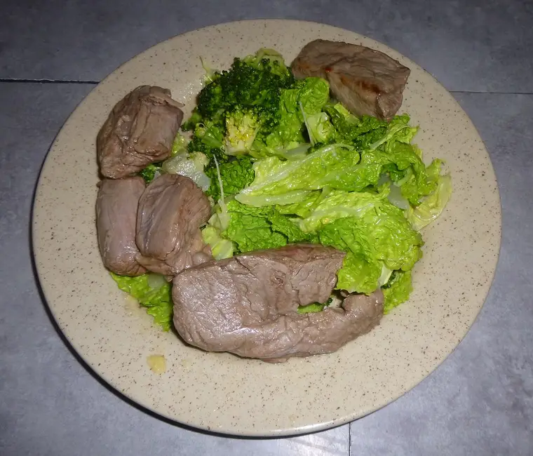 Chou vert braisé aux oignons et lardons dans une sauteuse