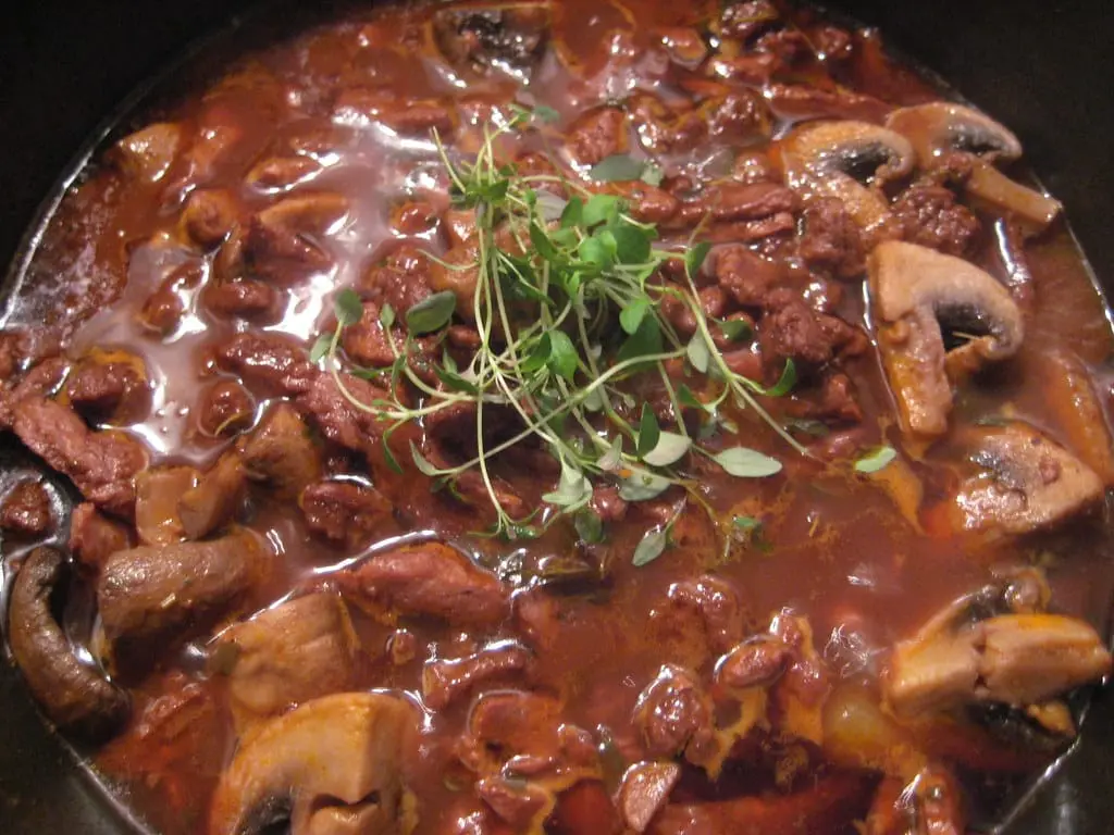 Cocotte de bœuf bourguignon avec carottes, oignons et champignons