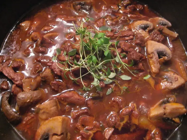 Cocotte de bœuf bourguignon avec carottes, oignons et champignons