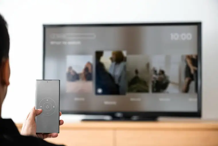 Une personne diffuse une vidéo depuis son smartphone vers un téléviseur connecté