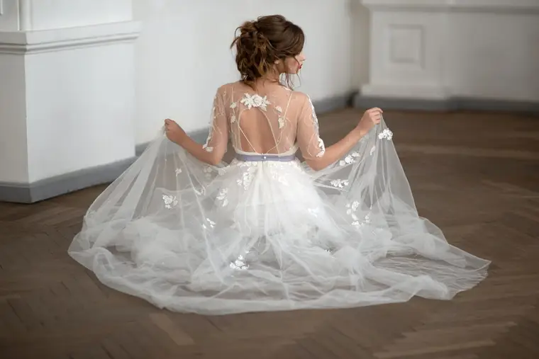 Mariée essayant une robe princesse en tulle avec une couturière