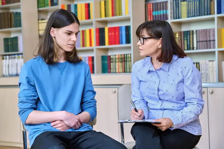 Jeune adulte échangeant avec une orthophoniste lors d’un bilan de lecture