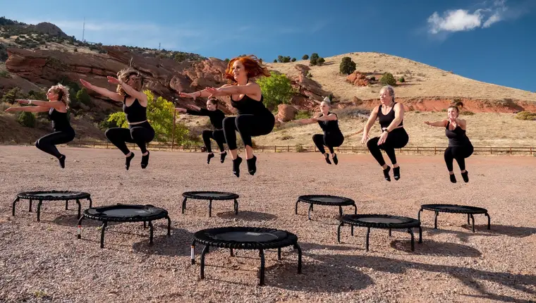 Adulte effectuant de petits rebonds sur un mini-trampoline dans un salon dégagé