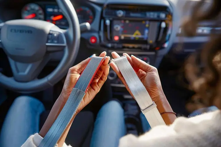 Passager inspectant la sangle et la boucle d’une ceinture de voiture