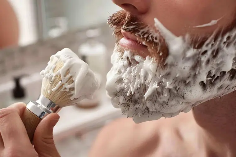 Blaireau synthétique montant une mousse dense dans un bol en céramique