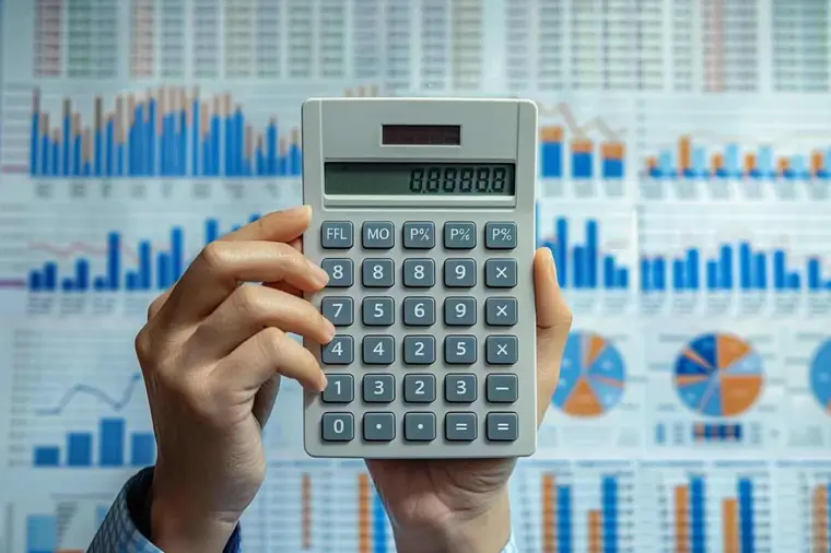 Personne calculant son budget immobilier avec relevés et calculatrice