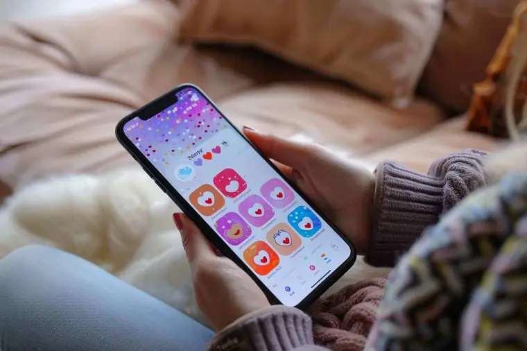 Femme souriante choisissant une animation affectueuse sur son téléphone