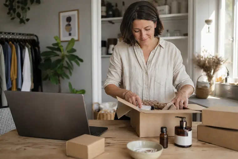 Commerçante préparant une commande en ligne dans un atelier lumineux