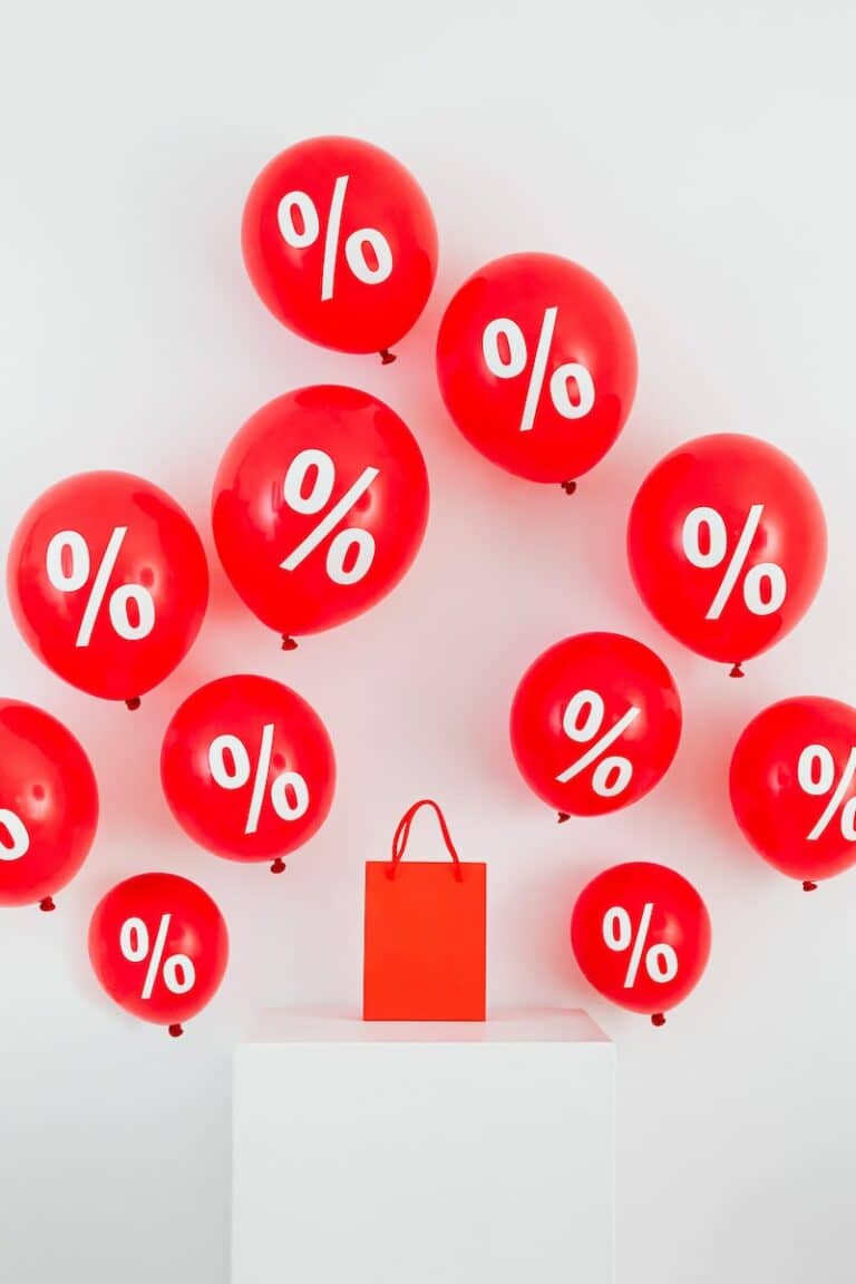 A Red Paper Bag in the Middle of Red Balloons With Percentage Symbols