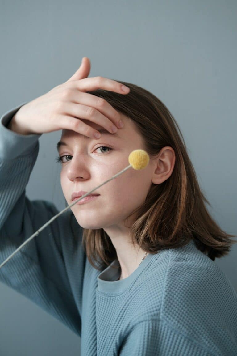 Young woman with decorative pompom on stick in studio