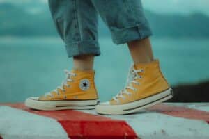 person wears yellow orange Converse All-Star high-top sneakers